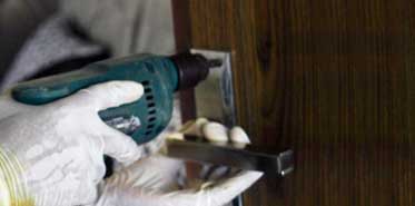 Carpenter drilling the door handle